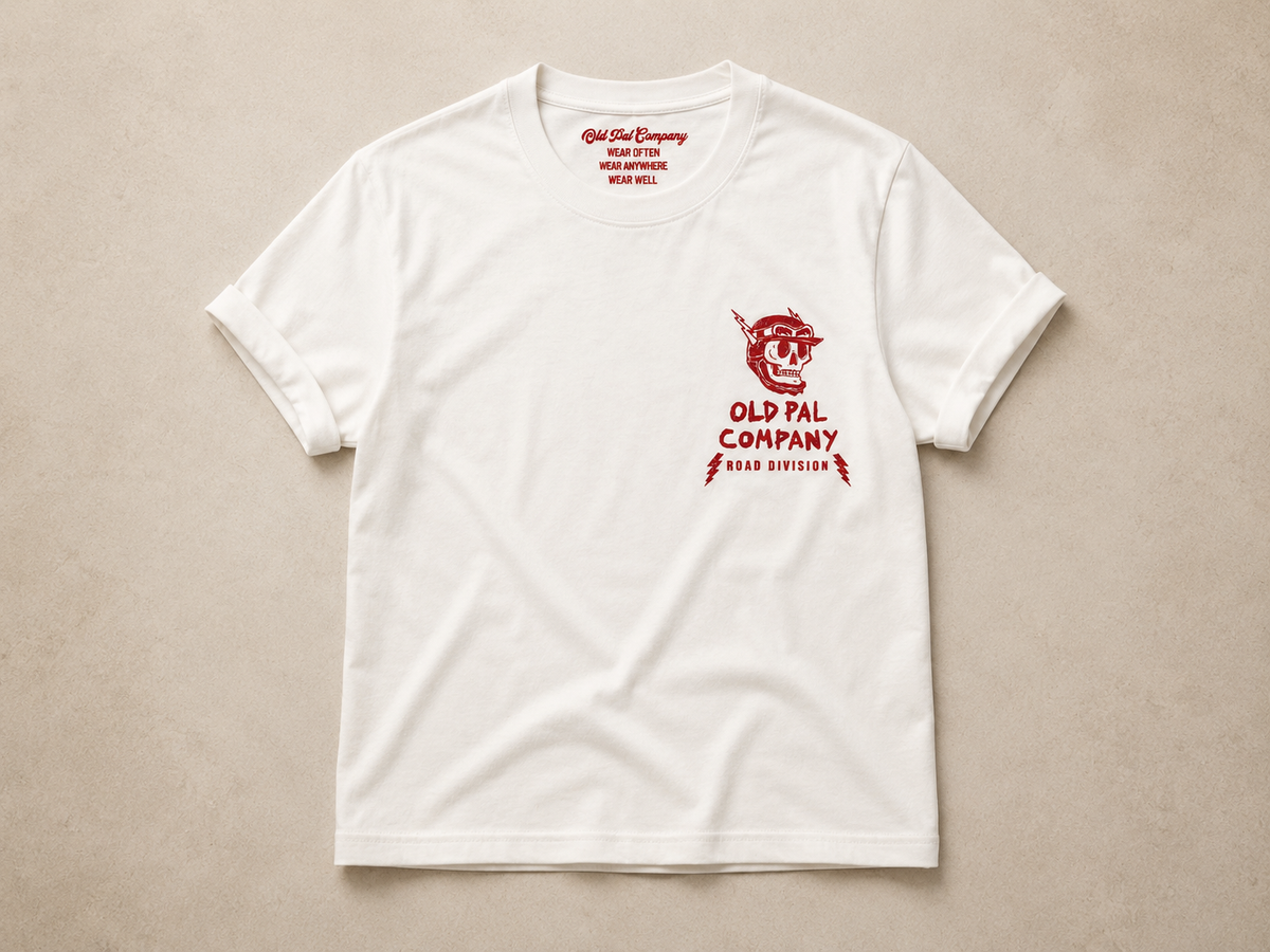 Classic white heavyweight T-shirt with vintage red Road Division graphic on the front featuring single skull motorcycle helmet, lightning bolts, and Old Pal Road Division company branding.