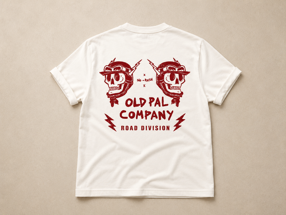Classic white heavyweight T-shirt with vintage red Road Division graphic on the back featuring mirrored skull motorcycle helmets, lightning bolts, and Old Pal Road Division company branding.