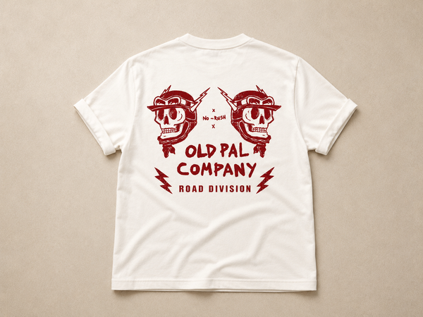 Classic white heavyweight T-shirt with vintage red Road Division graphic on the back featuring mirrored skull motorcycle helmets, lightning bolts, and Old Pal Road Division company branding.