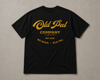 Pitch Black heavyweight cotton t-shirt with oversized Mustard old pal company graphic laid flat on neutral background